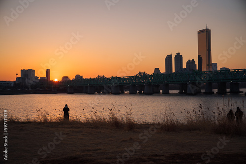 Sky Scraper in the city and the sunset scenery shows the silhouette of a person.