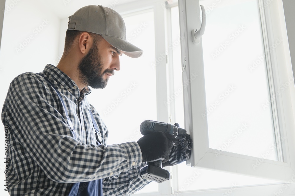 Fototapeta premium service man installing window with screwdriver