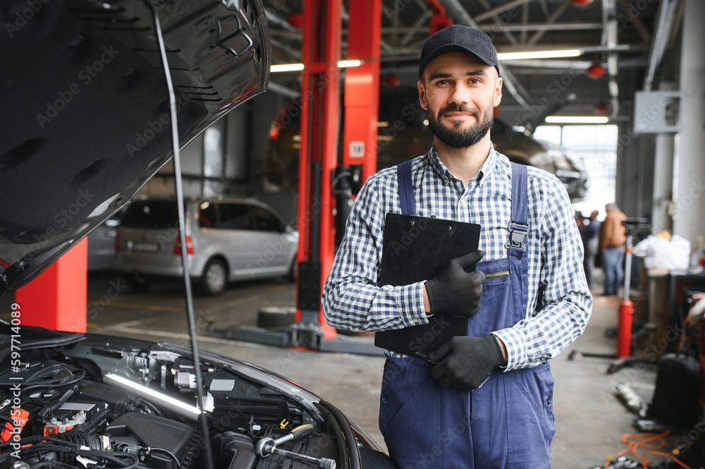 Handsome Car Mechanic is Posing in a Car Service. Handsome Car Mechanic is Posing in a Car Service.