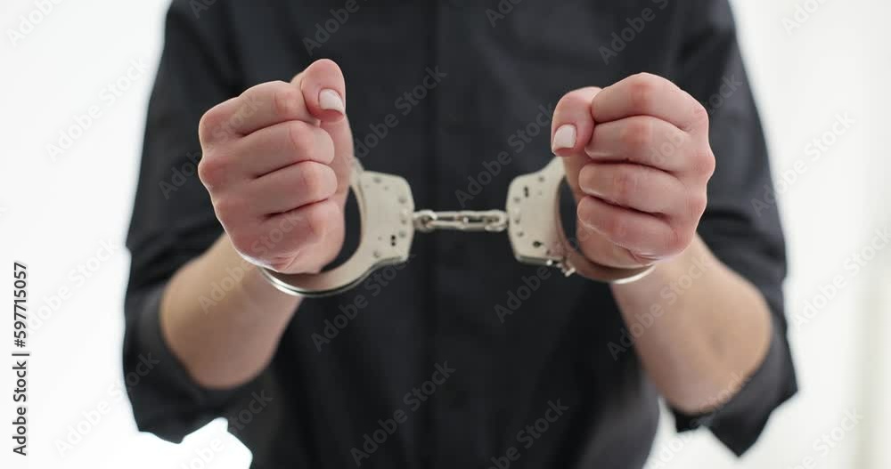 Woman with metal handcuffs in prison premise. Arrest of criminal for judgement in state court. Inevitability of punishment for illegal actions slow motion Woman with metal handcuffs in prison premise. Arrest of criminal for judgement in state court. Inevitability of punishment for illegal actions slow motion