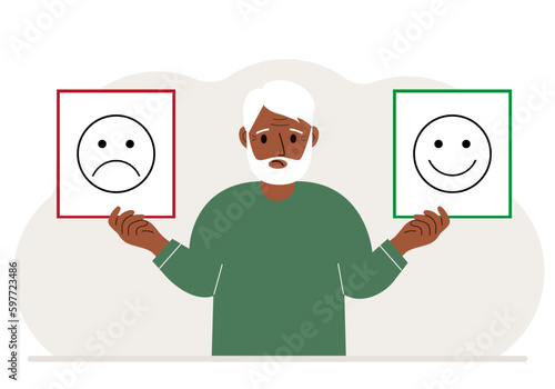 Sad man holds a card with a sad emoji in one hand and a smiling emoji in the other hand. The concept of emotions, masks or psychological help.