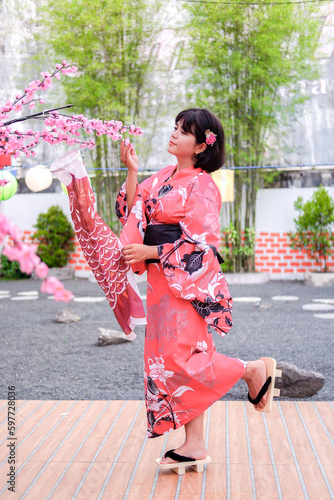 Photo a young woman wearing a kimono against a backdrop of cherry blossoms