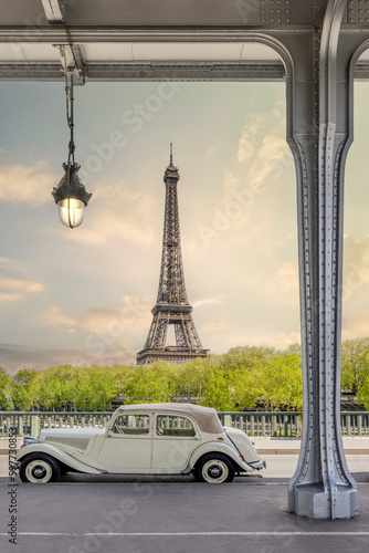 Paris, France. Eiffel Tower with Vintage French car at sunset photographed from Bir Hakeim Bridge. Iconic view and landscape in Europe photo