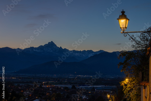 il profilo del monviso si staglia all'orizzonte durante il tramonto a saluzzo, caratteristico borgo del cuneese