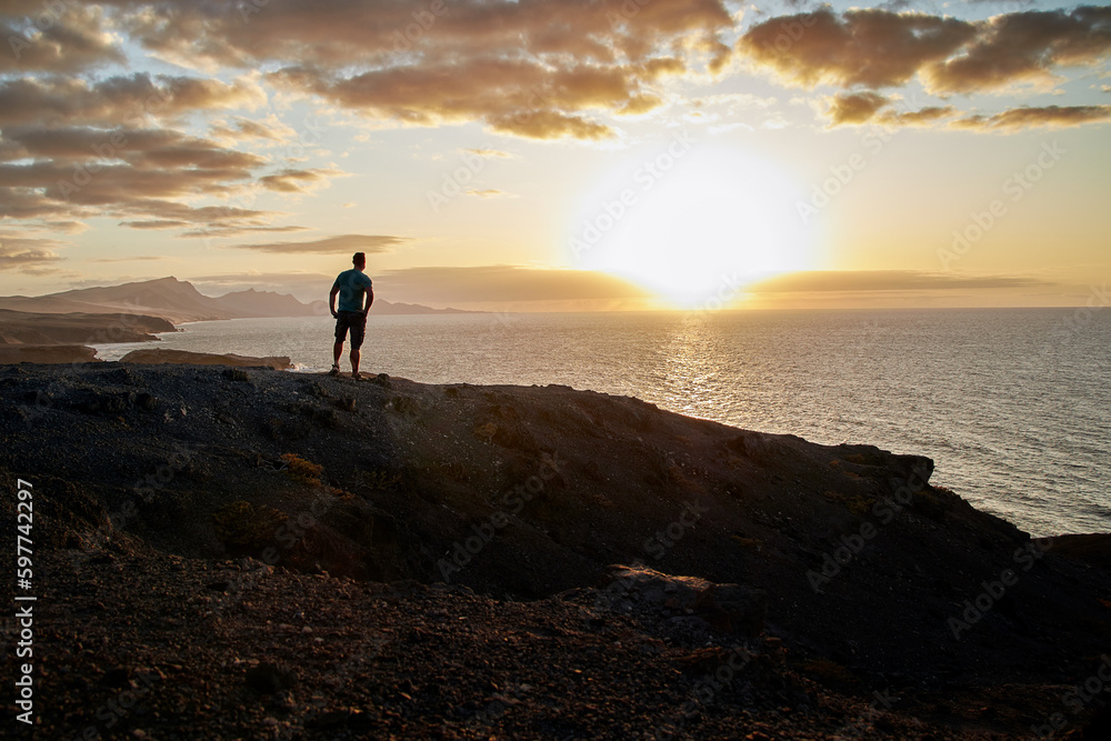 Sunset panorama, a man enjoys the beautiful view of the sea at La Pared, Fuerteventura in the Canary Islands