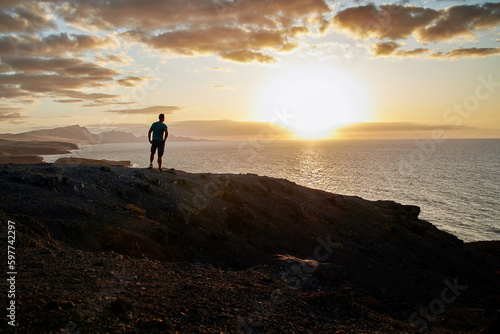 Sunset panorama  a man enjoys the beautiful view of the sea at La Pared  Fuerteventura in the Canary Islands