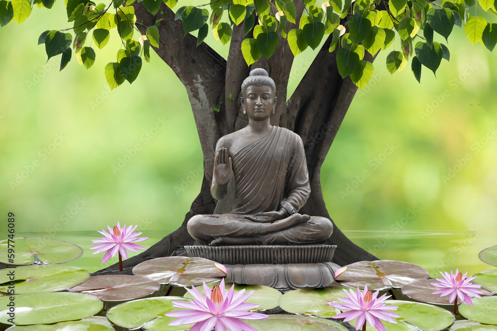 Buddha statue sitting under the bodhi tree on nature background. Stock