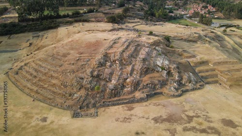 4K Aerial Drone pull back from Rodadero Rock Formation at Sacsayhuaman in Cusco, Peru. Camera tilts up. Ancient Incan ruins visible