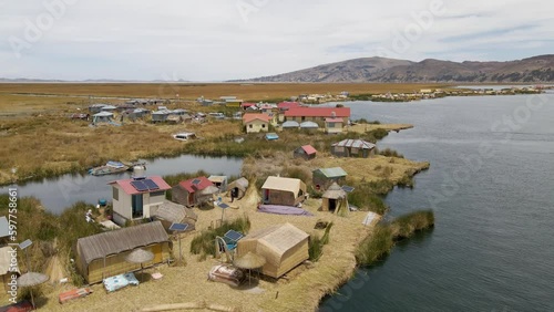4K Aerial Drone Orbit Arc around Uros Islands at Lake Titicaca near Puno, Peru. Authentic Boat, lake, reeds, and floating islands visible.