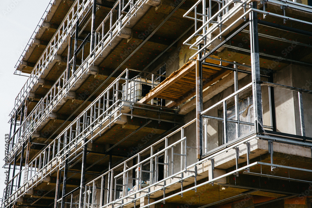 apartment house with scaffolding and protective net, for reconstruction and installation of insulation closeup apartment house with scaffolding and protective net, for reconstruction and installation of insulation closeup