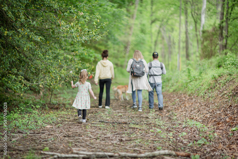 Family taking a nature walk through woods Family taking a nature walk through woods