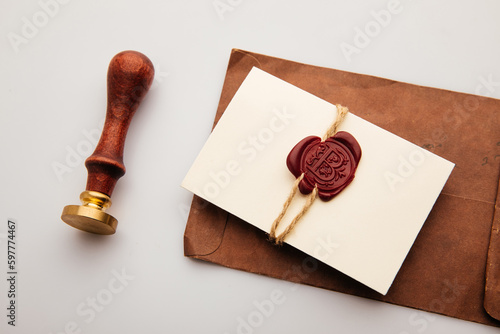 Paper envelope with red wax seal and stamp on a table