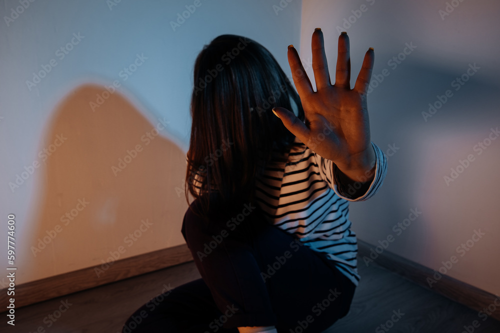 Girl with a raised hand making a stop sign gesture and crying in a room. Harassment and abuse prevention concept Girl with a raised hand making a stop sign gesture and crying in a room. Harassment and abuse prevention concept