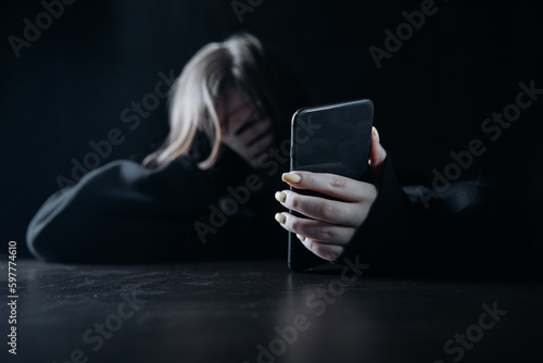 Young teenager female girl with smartphone felling lonely and hopeless. Online bullying and harassment concept