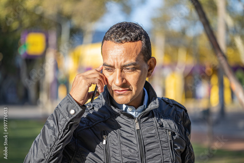 Latin young man talking on mobile phone.