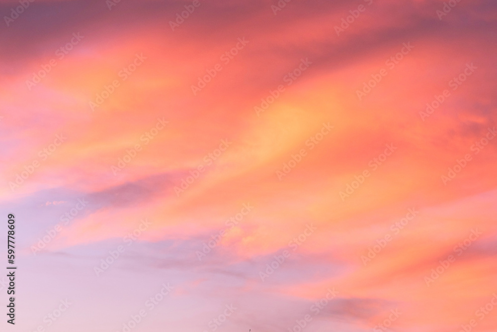 Sky with soft and fluffy pastel coral orange pink and blue colored clouds. Sunset background. Nature. sunrise. Instagram toned style