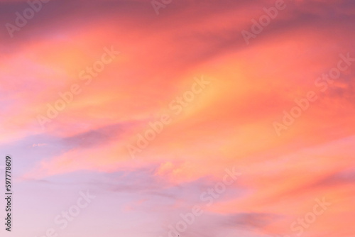 Sky with soft and fluffy pastel coral orange pink and blue colored clouds. Sunset background. Nature. sunrise. Instagram toned style © flowertiare