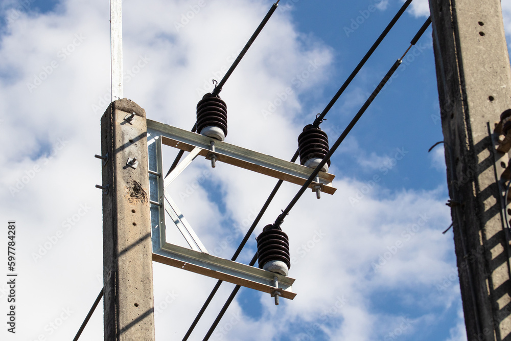 Porcelain insulator in nature day light and this is post type insulators. Bright blue sky bright sunlight in background. With electrical wires connected to electricity attached to electric pole. Porcelain insulator in nature day light and this is post type insulators. Bright blue sky bright sunlight in background. With electrical wires connected to electricity attached to electric pole.
