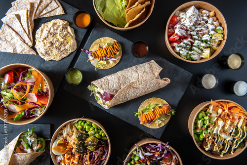 Fotografie Oriental and fusion health food composition from above on dark table, with veggi