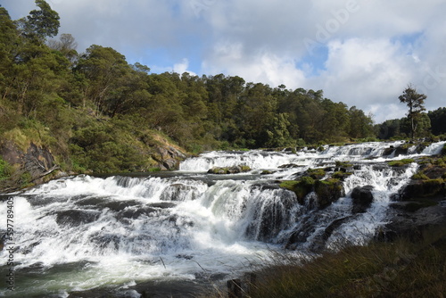 River flowing with green hills and blue sky