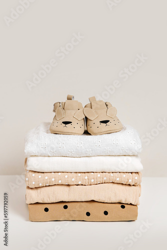 Wallpaper Mural Stack of baby clothes with baby shoes. Cotton clothes and muslin swaddle blanket in pastel colors. Clean freshly laundered, neatly folded kids clothes. Torontodigital.ca