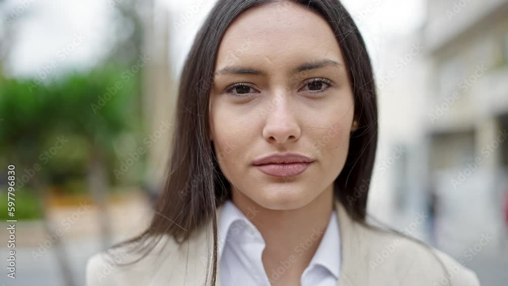 Young beautiful hispanic woman standing with serious expression at street Young beautiful hispanic woman standing with serious expression at street