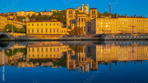 Fototapeta Naklejka Na Ścianę i Meble -  Lyon city skyline at sunrise, the Pont Bonaparte Bridge, vibrant water reflections on the Saone River, and La Basilique Notre Dame de Fourvière in France