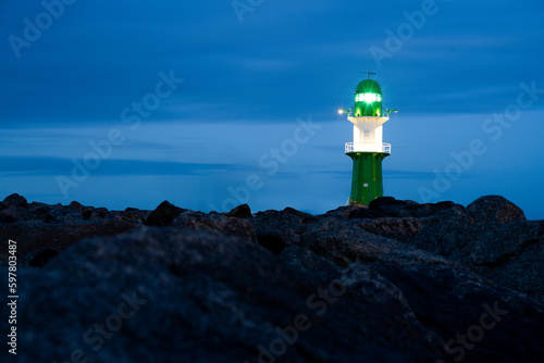 Leuchtturm Molenfeuer Westmole in Rostock mit Steinen am Meer Ostsee in Warnemünde Deutschland