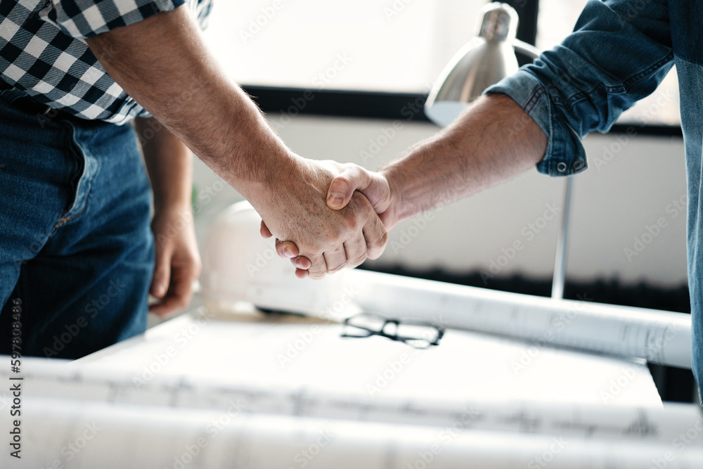 Architect and engineer workers shaking hands while working for teamwork and cooperation concept after finish a deal