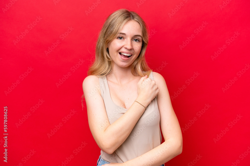 Fototapeta premium Young English woman isolated on red background celebrating a victory