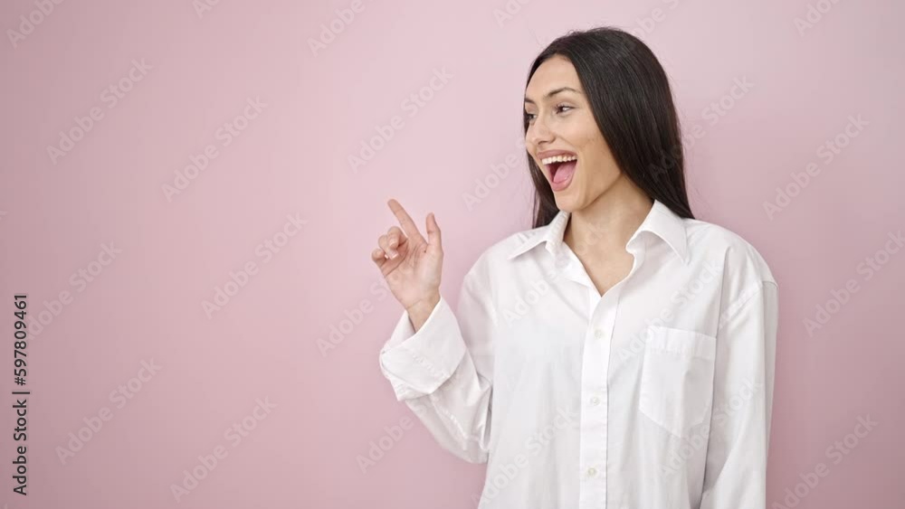 Young beautiful hispanic woman smiling confident pointing with fingers to side over isolated pink background Young beautiful hispanic woman smiling confident pointing with fingers to side over isolated pink background