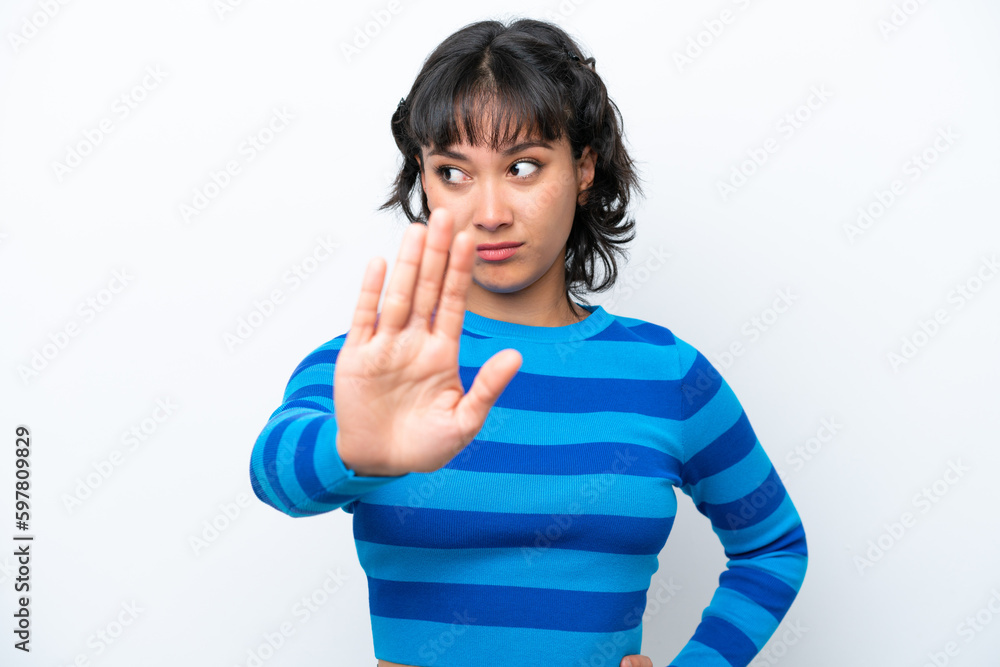 Young Argentinian woman isolated on white background making stop gesture and disappointed