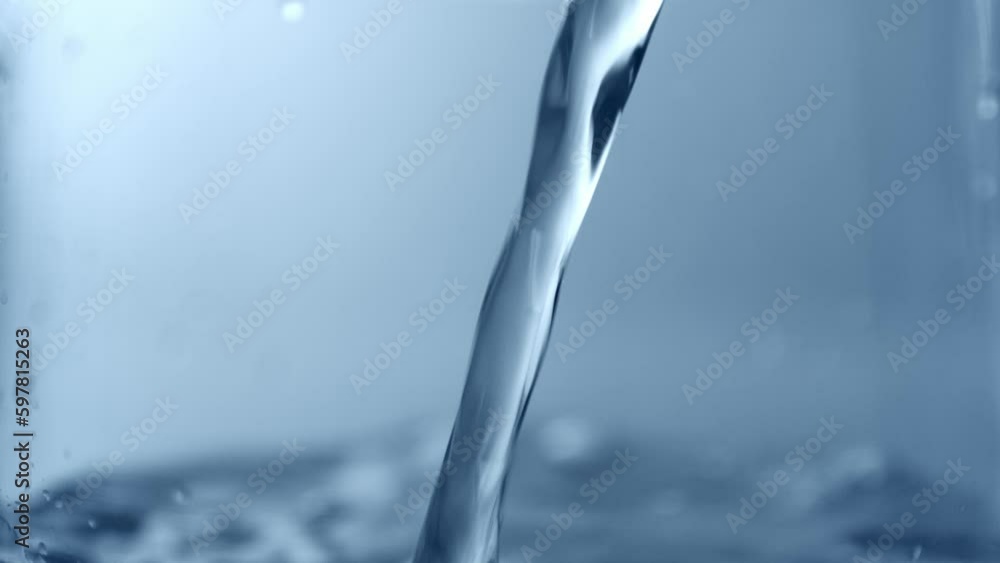 Pouring water. Closeup. Blue tone