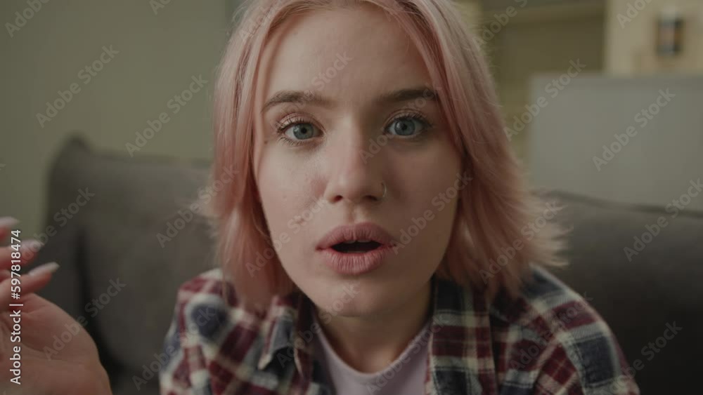 Exited Woman Showing Wow Emotion at Camera. 20s female starring at camera sitting on couch at home. Unbelievable emotion at camera. Exited Woman Showing Wow Emotion at Camera. 20s female starring at camera sitting on couch at home. Unbelievable emotion at camera.