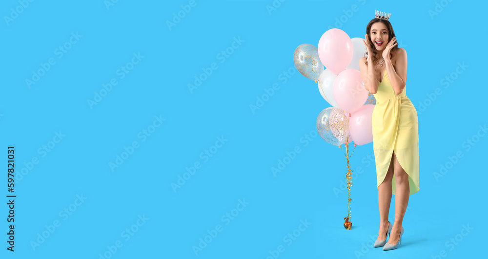 Beautiful surprised young woman in prom dress and with balloons on light blue background with space for text Beautiful surprised young woman in prom dress and with balloons on light blue background with space for text