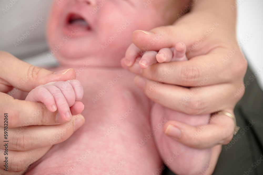 HOUSTON, TEXAS - APRIL 26TH 2023: a newborn baby’s tiny pink fingers are photographed close up in their mother’s hands to compare the size. You can see every detail and line on the skin. HOUSTON, TEXAS - APRIL 26TH 2023: a newborn baby’s tiny pink fingers are photographed close up in their mother’s hands to compare the size. You can see every detail and line on the skin.