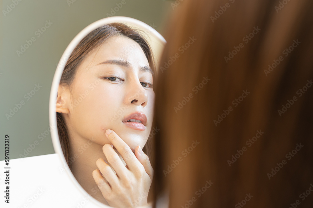 Dermatology, puberty asian young woman, girl looking into mirror