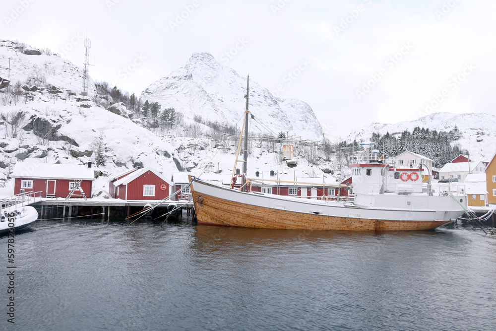 Traditional wooden houses, rorbuer in the small fishing village of Nusfjord, Lofoten islands, Norway, Europe. Noewegian fjord with fish boats