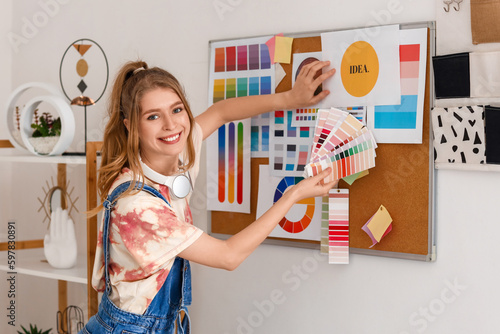 Bilde på lerret Female graphic designer with color palettes near pinboard in office
