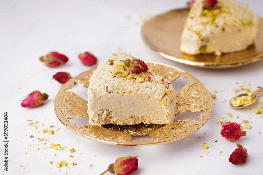 Plates with pieces of tasty Tahini halva on white background Plates with pieces of tasty Tahini halva on white background