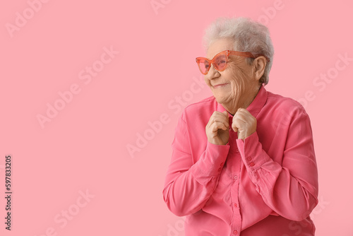 Happy senior woman on pink ...