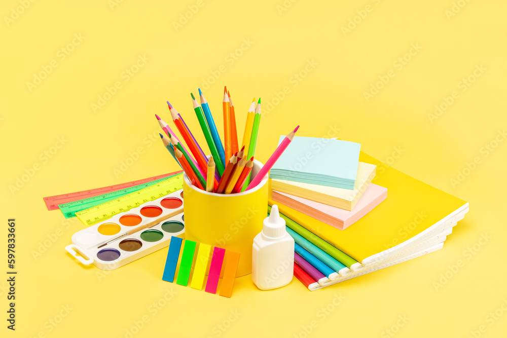 Fototapeta premium A set of school stationery, pencils, rulers, paints, glue, notepad, notebook on a yellow background. Copy Space