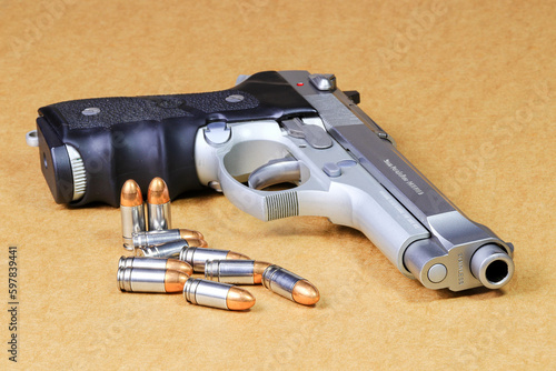 bullet 9mm parabellum and Beretta 92FS, M9 gun on brown paper background. photo
