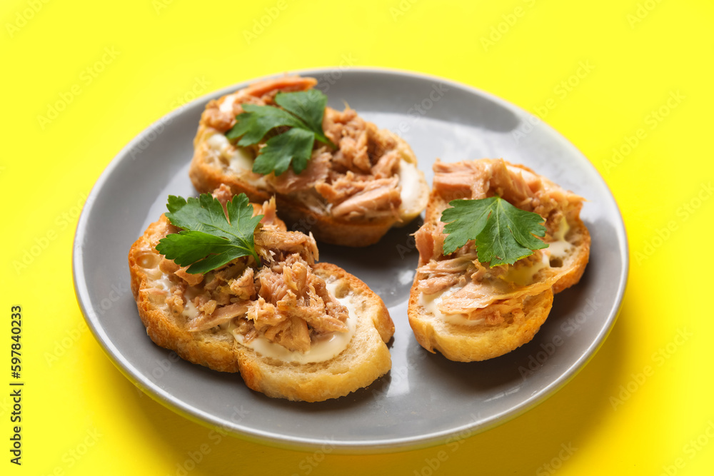Plate with tasty tuna bruschettas on yellow background Plate with tasty tuna bruschettas on yellow background