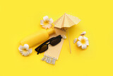 Composition with sunglasses, bottle of sunscreen, plumeria flowers and umbrella on yellow background