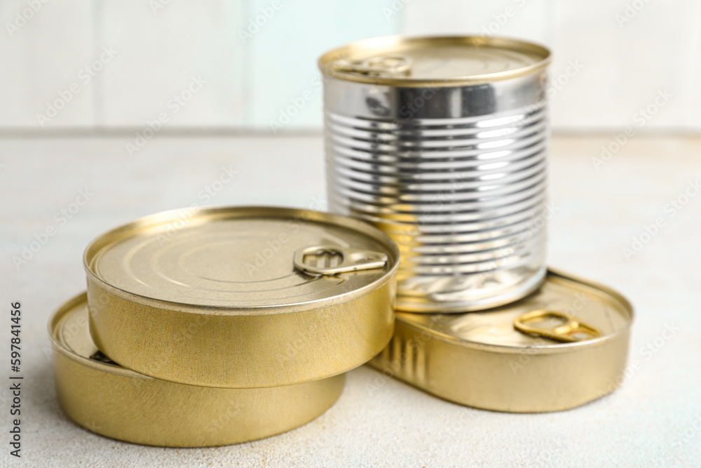 Tin cans with fish on white table Tin cans with fish on white table