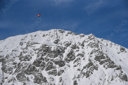 TOPR helicopter in the sky during a rescue operation in the Tatra Mountains in Poland in winter.