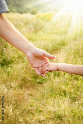 hands of parent and child in nature