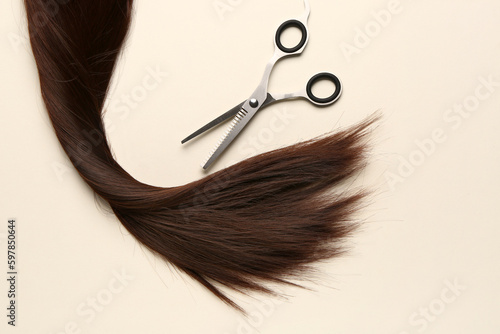 Brown hair with scissors on light background