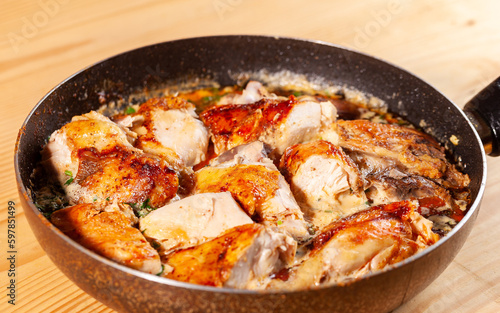 Shkmeruli, chicken in garlic sauce on a frying pan